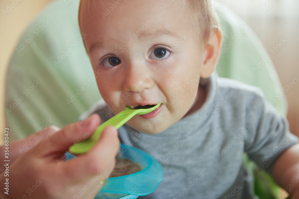 Closeup little baby eating tasty porridge milk Closeup little baby eating tasty porridge milk