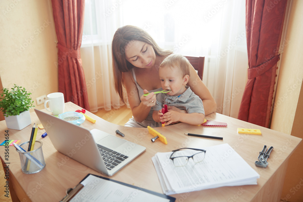 Mother feeding baby during online work break time Mother feeding baby during online work break time