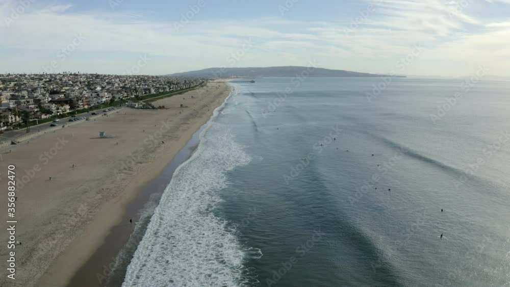 Aerial shot of people at beach by city against sky, drone flying over coastline - Manhattan Beach, California Aerial shot of people at beach by city against sky, drone flying over coastline - Manhattan Beach, California