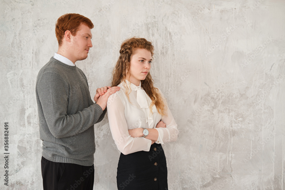 Unhappy young couple arguing, offended affronted woman ignoring man staying her back husband wants to apologize to frustrated wife, family conflict at home, bad marriage relationships concept. Redhead