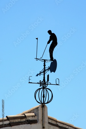 Black golfing weathervane against a blue sky, Andalusia, Spain.
