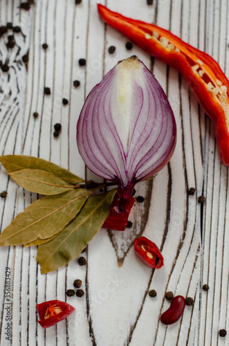 Obraz na plátně red sweet onion on a black background with hot pepper and spices