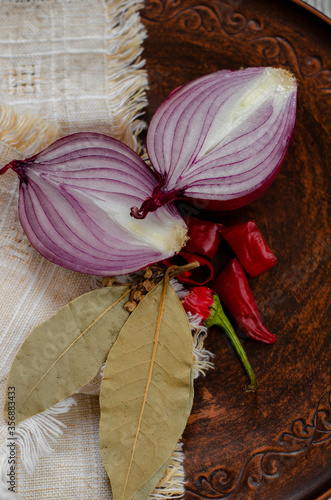 red sweet onion on a black background with hot pepper and spices photo