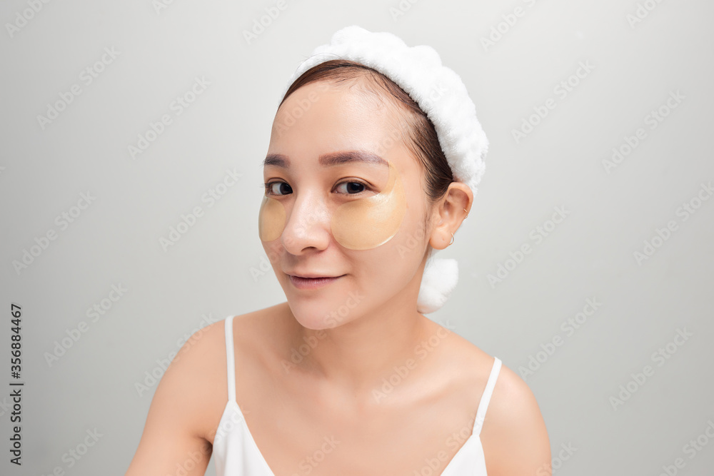 close-up of beautiful young Asian woman with bath towel on head covering her head on white background. close-up of beautiful young Asian woman with bath towel on head covering her head on white background.