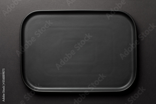 Top view of empty black plate on black background