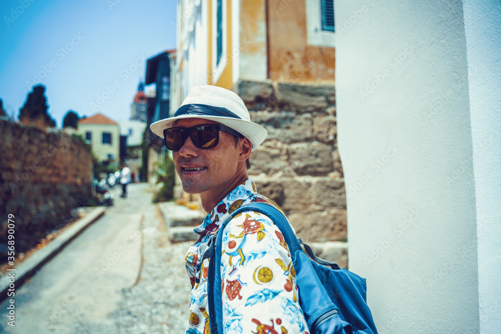 Happy man traveler is walking and exploring Greek island of Rhodes, Dodecanese, Greece