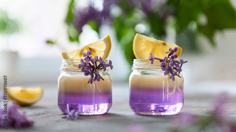 Alcoholic shot cocktails with vanilla liqour in tiny jars on gray concrete background. Summer party. Shot drinks with lilac on the background. Bar menu Alcoholic shot cocktails with vanilla liqour in tiny jars on gray concrete background. Summer party. Shot drinks with lilac on the background. Bar menu