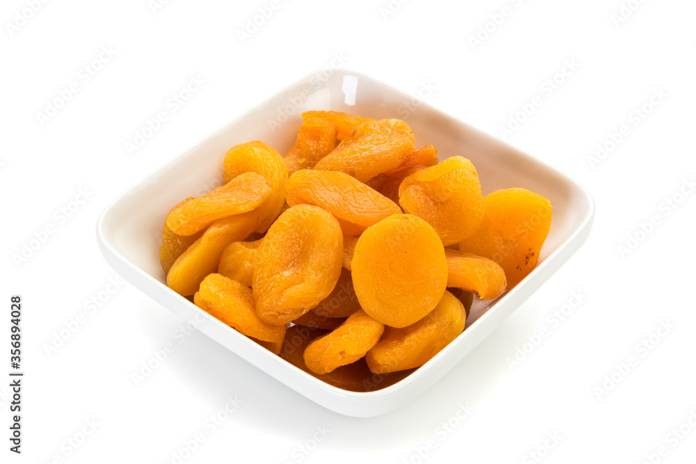 Preserved fruit. Dried sulfurized apricots in square white bowl isolated on white background. Preserved fruit. Dried sulfurized apricots in square white bowl isolated on white background.