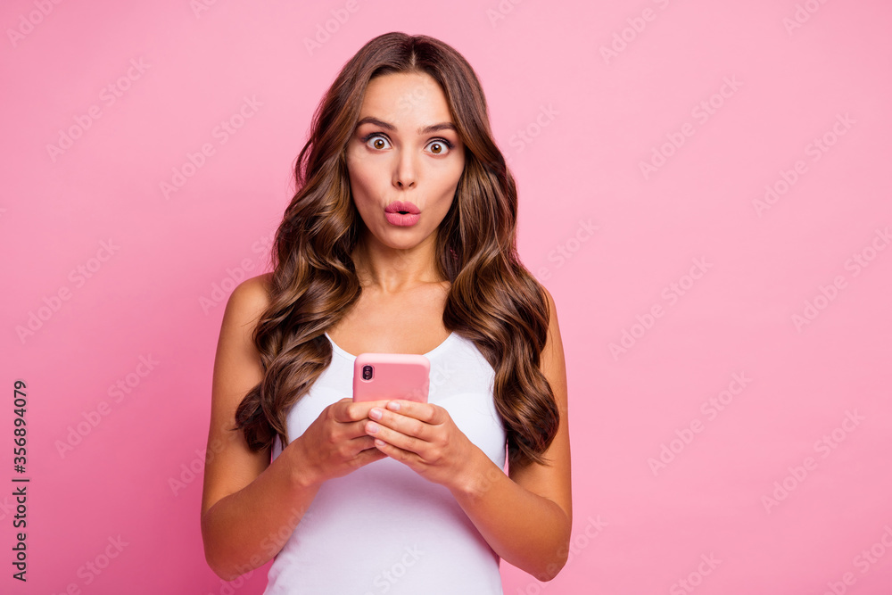 Impossible. Photo of pretty curly lady open mouth hold telephone hands chatting read bad negative comments blog wear white casual singlet isolated pink color background Impossible. Photo of pretty curly lady open mouth hold telephone hands chatting read bad negative comments blog wear white casual singlet isolated pink color background