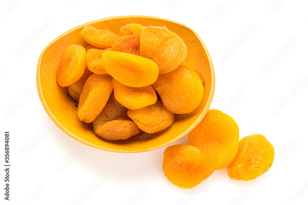 Preserved fruit. Dried sulfurized apricots in wooden bowl isolated on white background. High angle view. Preserved fruit. Dried sulfurized apricots in wooden bowl isolated on white background. High angle view.