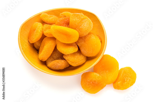 Preserved fruit. Dried sulfurized apricots in wooden bowl isolated on white background. High angle view.