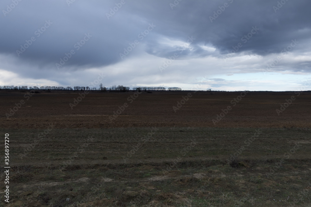 Gloomy steppe landscape. Beautiful cloudy sky over the field.