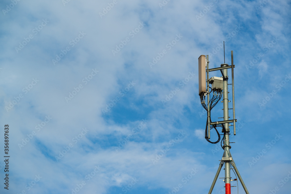 Telecommunication Tower, Cell Site, Cell Tower, or Cellular Base Station is a cellular-enabled mobile device site on blue sky background. Telecommunication Tower, Cell Site, Cell Tower, or Cellular Base Station is a cellular-enabled mobile device site on blue sky background.