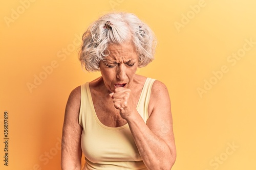 Senior grey-haired woman wearing casual clothes feeling unwell and coughing as symptom for cold or bronchitis. health care concept.