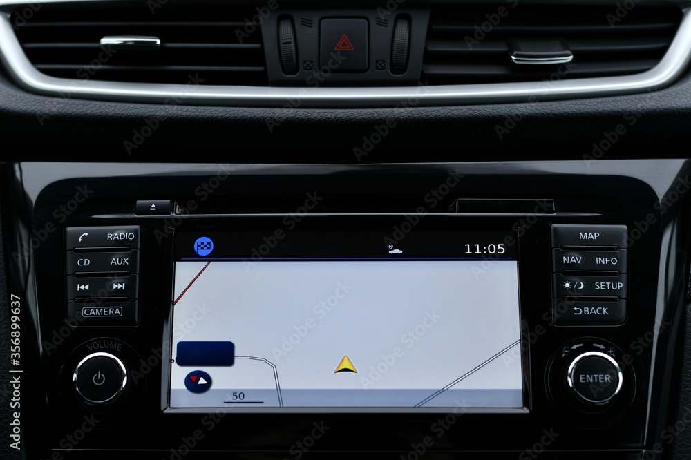 Fototapeta premium The car panel. A built computer screen with a navigator and an emergency stop button between air conditioning nozzles.