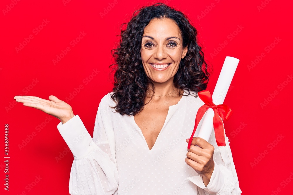 Middle age beautiful woman holding graduate degree diploma celebrating achievement with happy smile and winner expression with raised hand Middle age beautiful woman holding graduate degree diploma celebrating achievement with happy smile and winner expression with raised hand