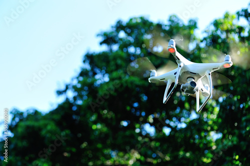 White drone with camera flying taking pictures of lychee fruits  in summer photo