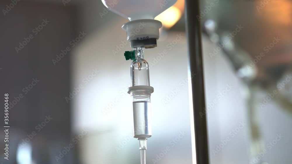 Close up of a Intravenous Fluid Drip in a hospital under low lighting conditions Close up of a Intravenous Fluid Drip in a hospital under low lighting conditions