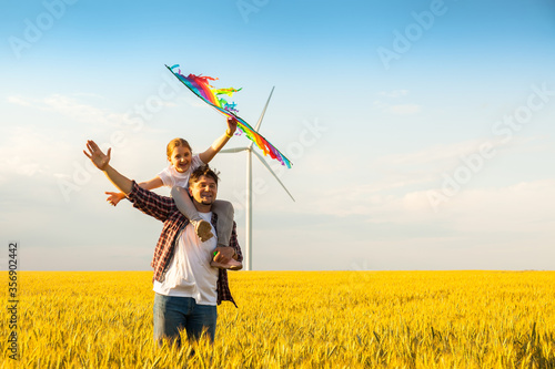 father and daughter having fun  playing with kite together