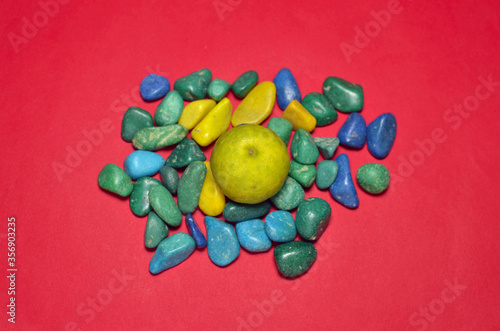 Yellow Lemon on multicolor pebbles