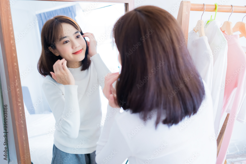 Asian woman checking face with mirror with clothes lifestyle at home Asian woman checking face with mirror with clothes lifestyle at home