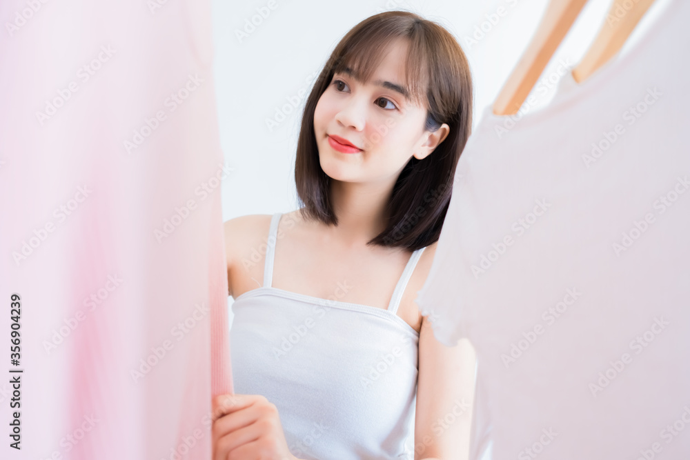 Asian woman choosing clothes dress-up closet collection mirror at home Asian woman choosing clothes dress-up closet collection mirror at home