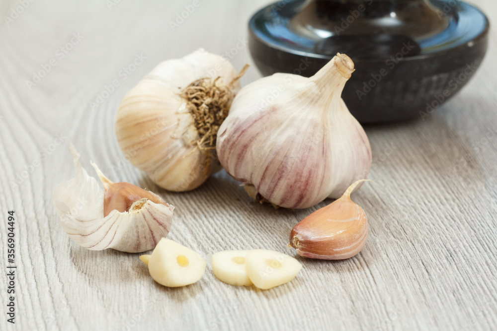 Raw garlic bulbs on a gray wooden background. Raw garlic bulbs on a gray wooden background.