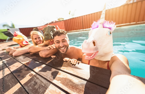 Fotografía Crazy friends selfie doing pool party wearing bizarre mask - Young people having