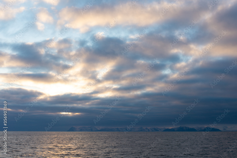 Beautiful cloud formation during the Arctic summer on Spitsbergen. Warm light behind the clouds.
