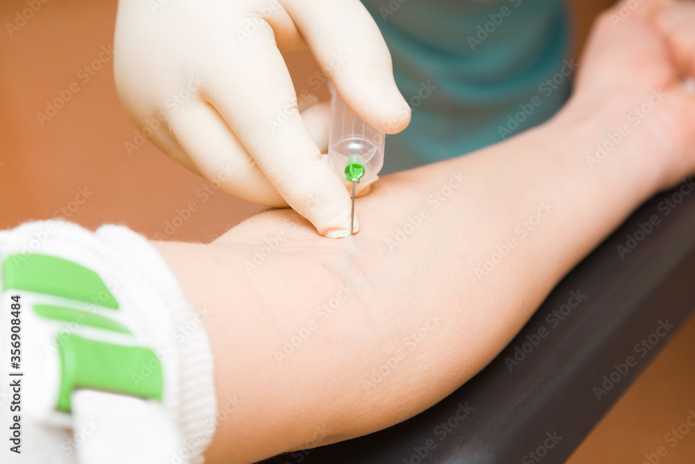 Doctor hand in rubber protective glove using syringe and taking blood from vein of woman arm. Visit to physician at office. Closeup. Doctor hand in rubber protective glove using syringe and taking blood from vein of woman arm. Visit to physician at office. Closeup.