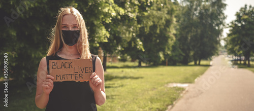 Black Lives Matter protest against the end of racism. Poster on violation of human rights. A white teenager holds a poster with the inscription protest against racism, anti-racism, equality.