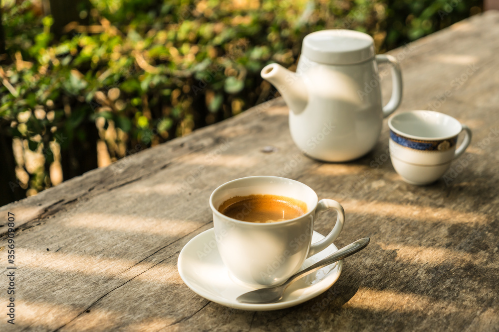 coffee cup with teapots background on the wood table with sunlight coffee cup with teapots background on the wood table with sunlight