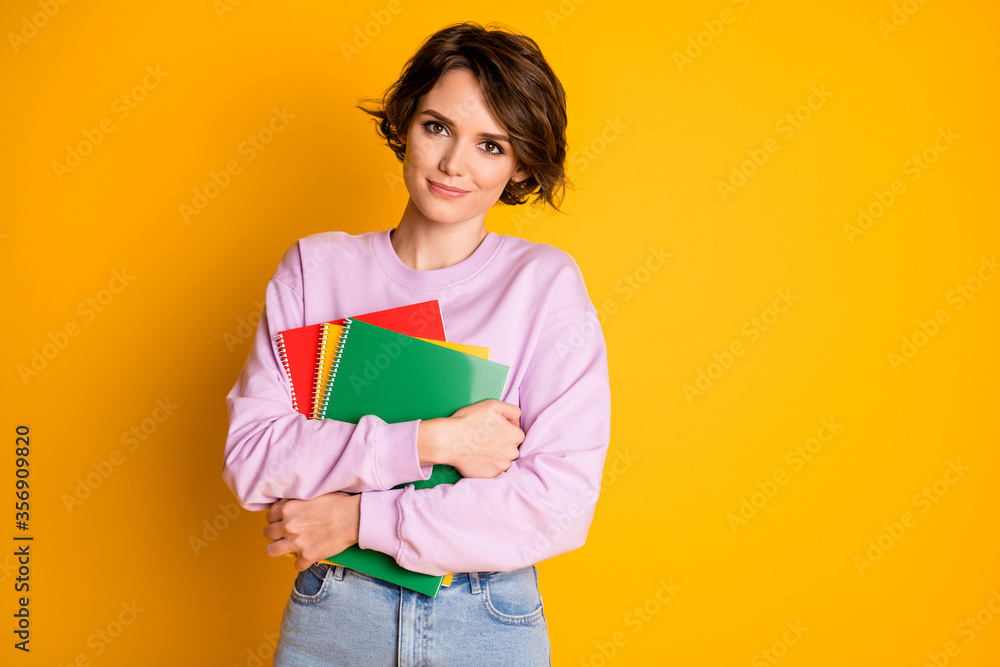 Portrait of her she nice attractive lovely pretty content cheery girl holding in hands educational materials courses classes isolated on bright vivid shine vibrant yellow color background Portrait of her she nice attractive lovely pretty content cheery girl holding in hands educational materials courses classes isolated on bright vivid shine vibrant yellow color background