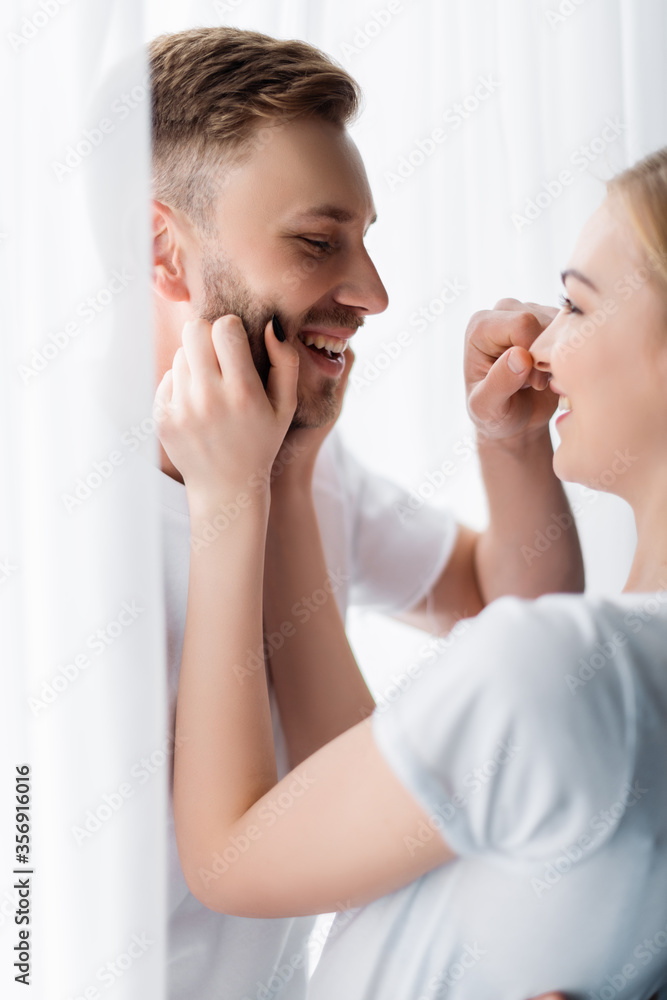 side view of happy man touching nose of cheerful girl side view of happy man touching nose of cheerful girl