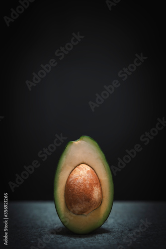 Halved avocado on black background with space for your text