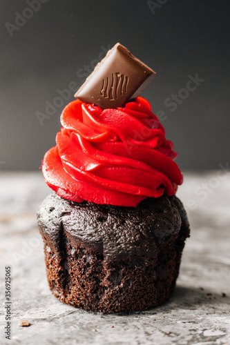 Delicious chocolate cupcakes on dark table. Tasty cupcakes with butter cream, on wooden table