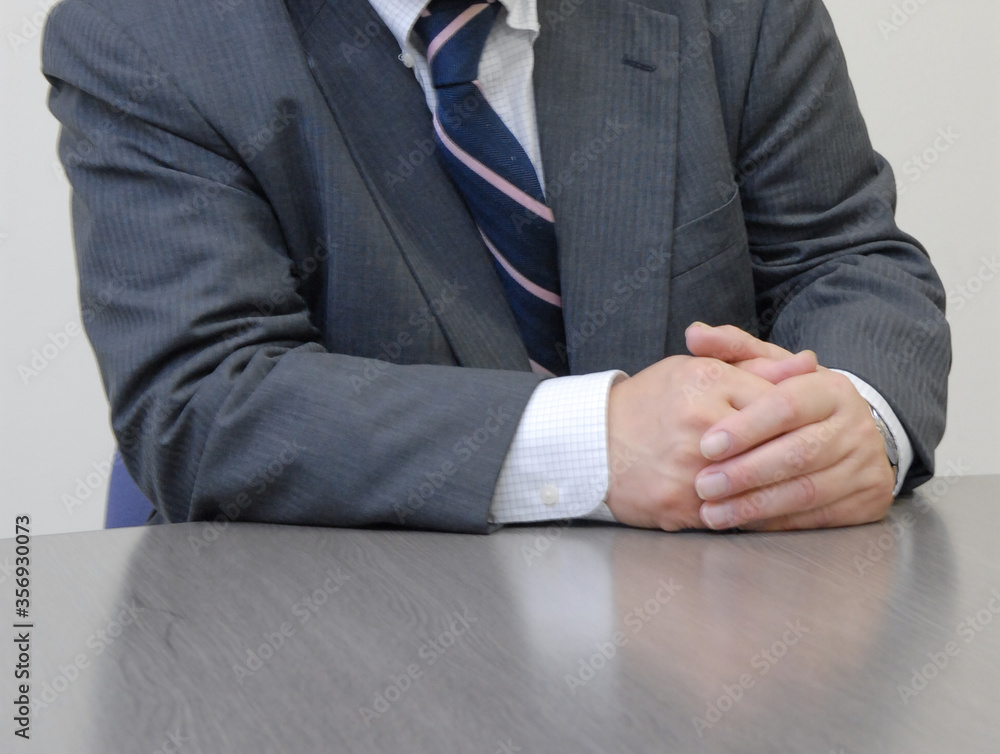 Obraz premium 身振り手振りのジェスチャーを交えて話しをするビジネスマン 手元アップ