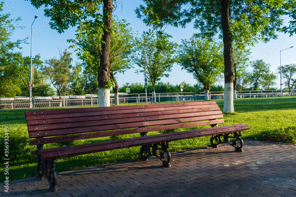 A wooden bench on a cobblestone path in the Park 3