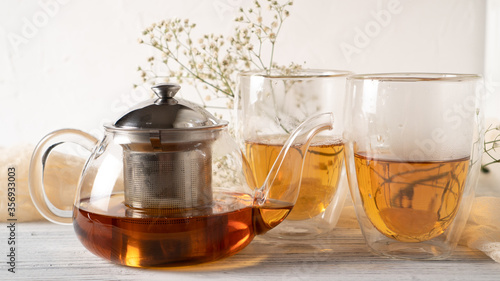 Morning romantic tea for couples. Black tea in regular glass teapot. Hot tea in double wall cups. Double walled mugs.