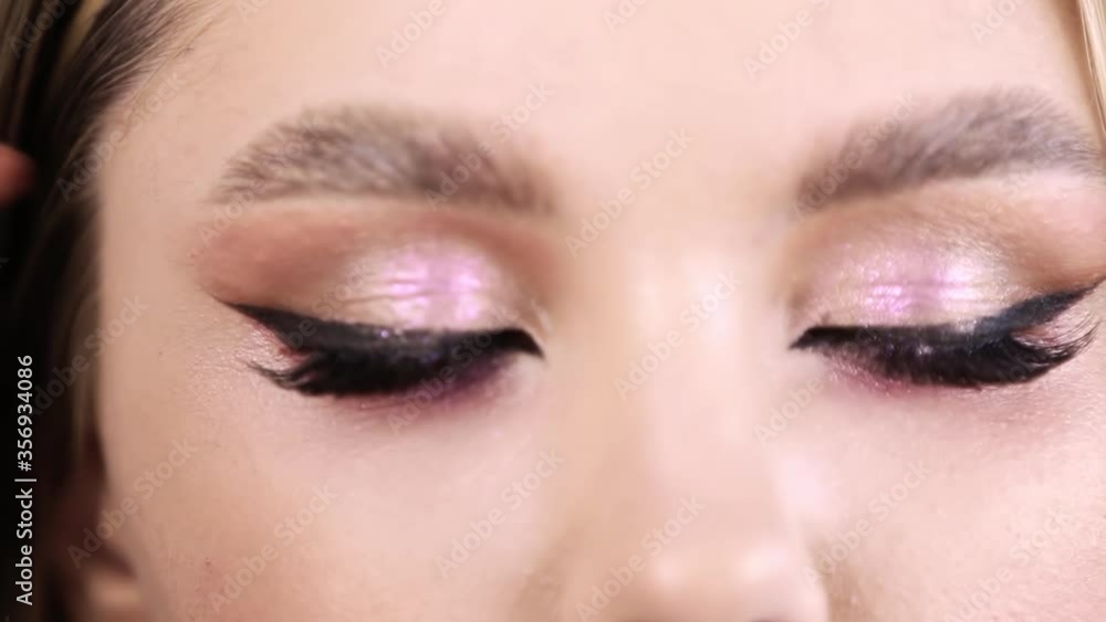 Makeup artist applies eye shadow . Hand of visagiste, painting cosmetics of young beauty model girl . Make up in process. Perfect Makeup. Skin. Beauty concept Makeup artist applies eye shadow . Hand of visagiste, painting cosmetics of young beauty model girl . Make up in process. Perfect Makeup. Skin. Beauty concept
