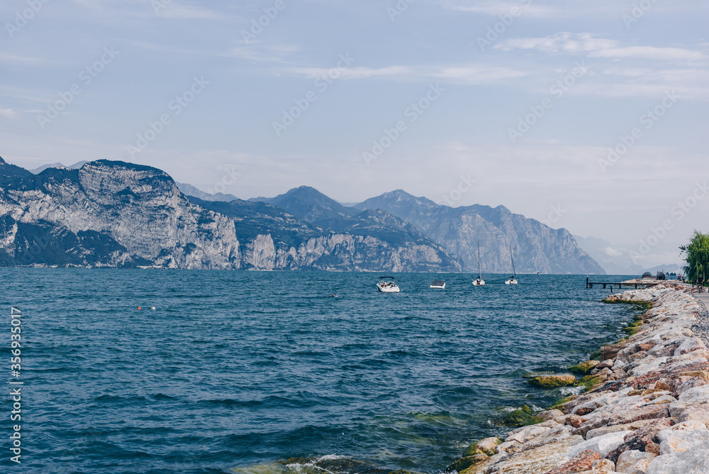 Lago di Garda during windy morning with majestic mountains on the background