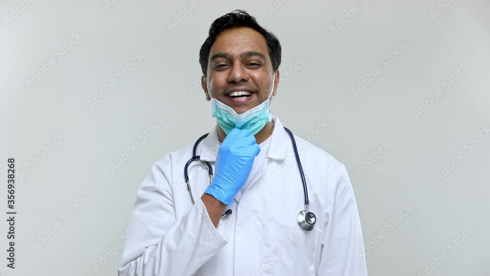 Doctor Taking off Medical Mask after Work Smilling. Indian Man Doctor Isolated Medical mask and Gloves. Doctor Taking off Medical Mask after Work Smilling. Indian Man Doctor Isolated Medical mask and Gloves.