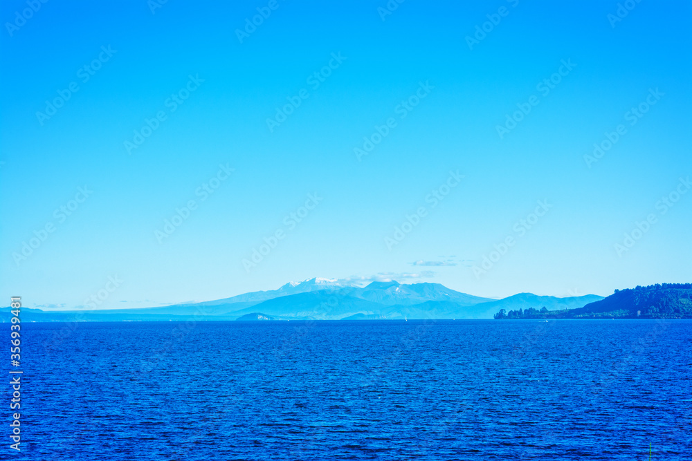 Cloudless say over volcanic cones of Ruapehu towering over great lake of Taupo. North Island Volcanic Plateau, New Zealand Cloudless say over volcanic cones of Ruapehu towering over great lake of Taupo. North Island Volcanic Plateau, New Zealand