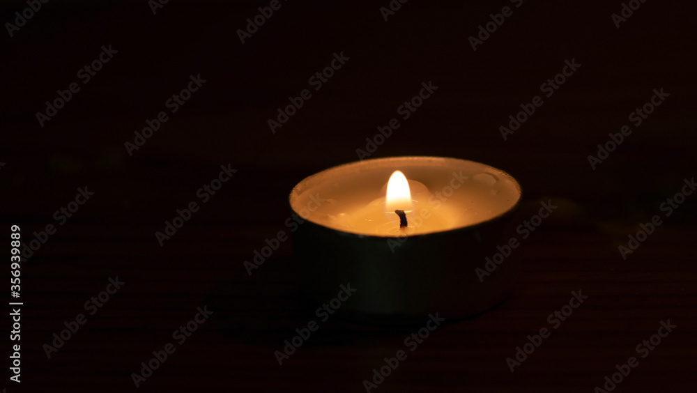 The candle flame is approaching the dark background in the night. The candle flame is approaching the dark background in the night.