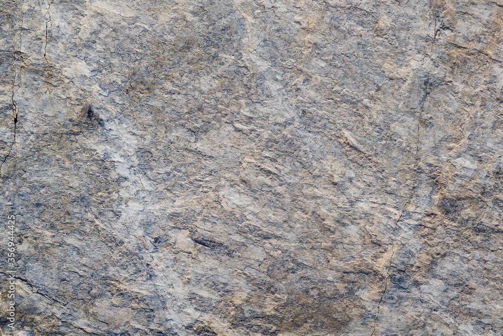 Fototapeta premium Mountain stone. Macro photo. Rough texture of mountain wild stone. Rough surface of an ancient mountain. Grunge texture. Laminated surface. Abstract grunge background. Marble. Granite.