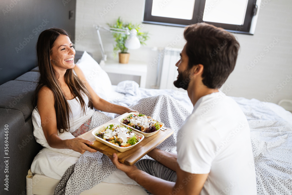 Happy young couple have breakfast at the bed. Care and romance at the morning. Happy young couple have breakfast at the bed. Care and romance at the morning.