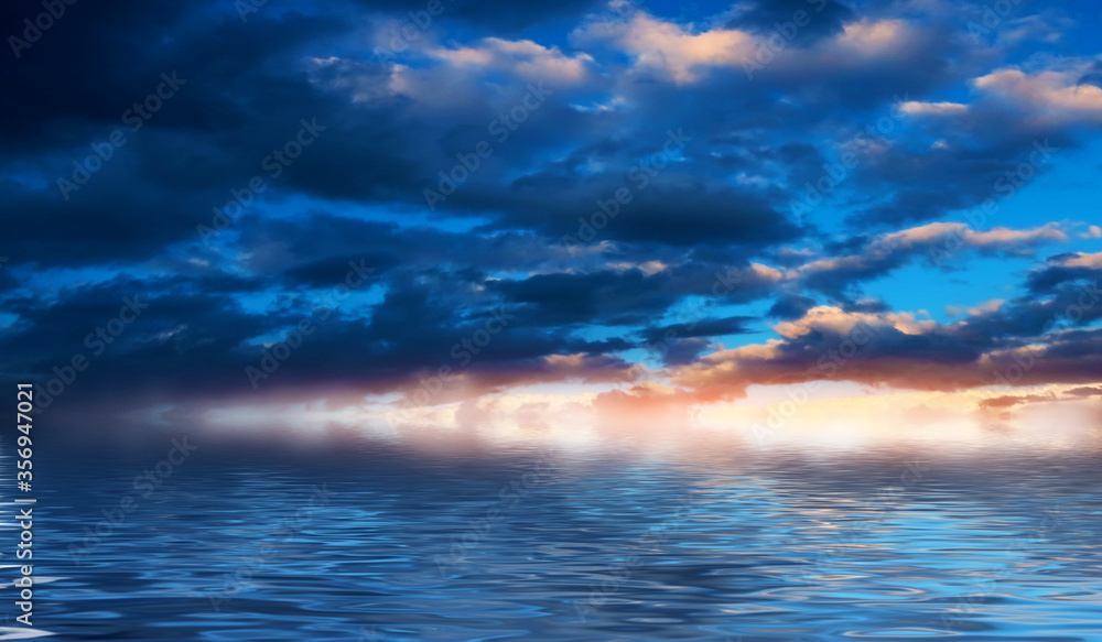 Summer seascape. Blue sea and sky with fluffy clouds. Bright sunset on a tropical beach