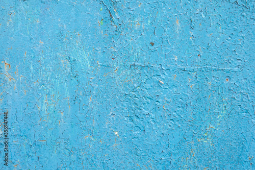 the surface of the old metal, pitted with rust, covered in old blue paint