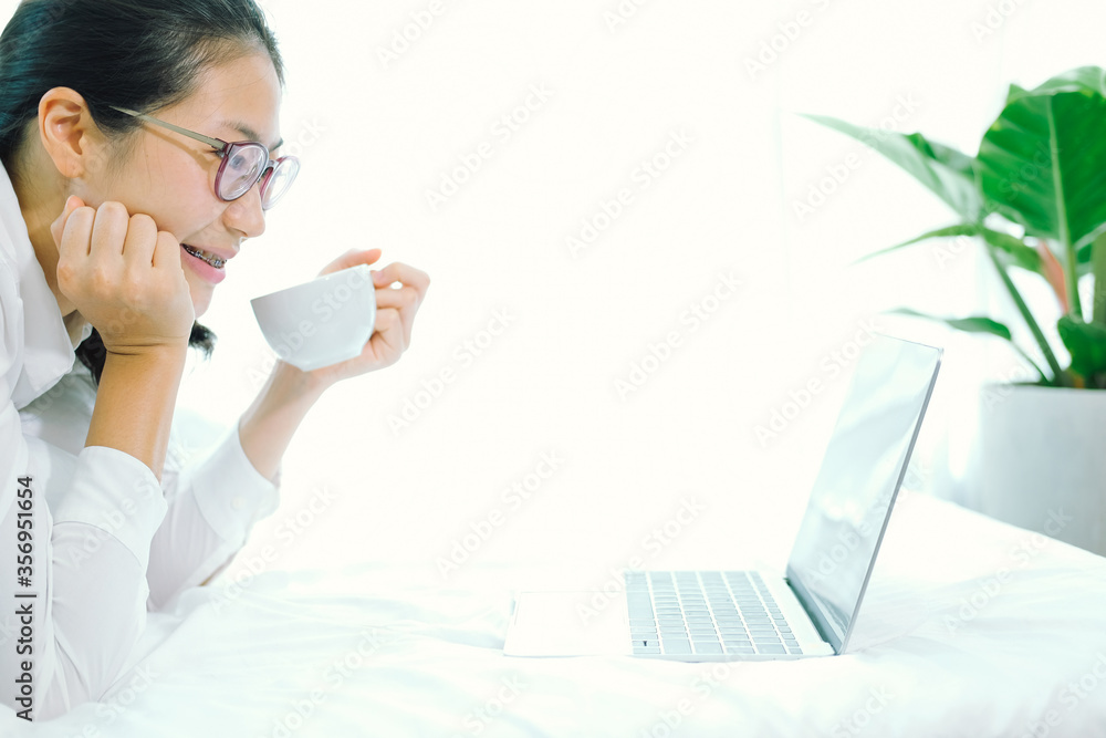 asian woman using computer on bed in bedroom. work remotely at home. leisure lifestyle asian woman using computer on bed in bedroom. work remotely at home. leisure lifestyle