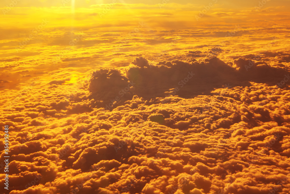 bright cloudscape in the sunlight , flying above the clouds in the sunlight